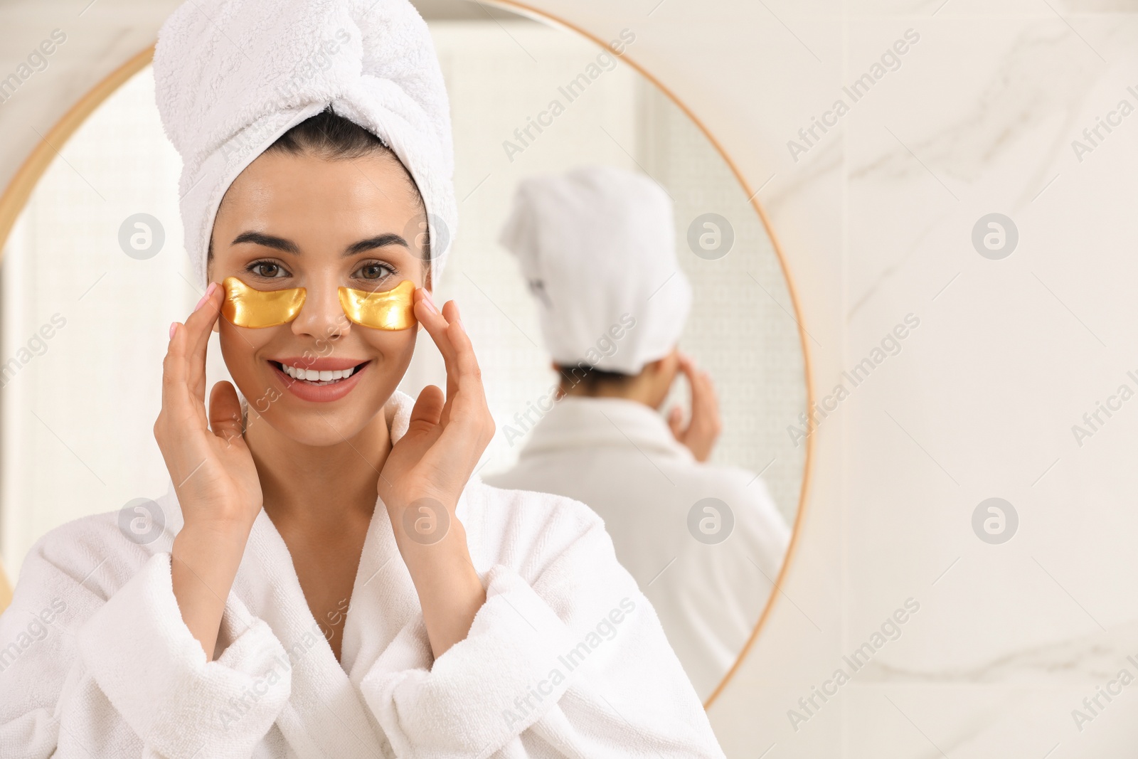 Photo of Beautiful young woman with under eye patches at home, space for text