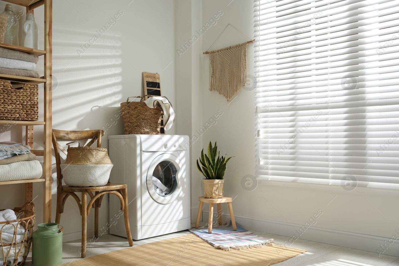 Photo of Modern washing machine in laundry room interior