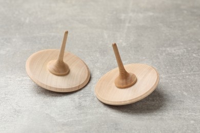 Wooden spinning tops on grey textured background, closeup