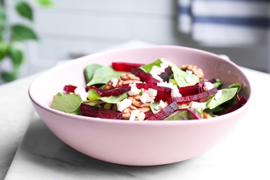 Photo of Delicious beet salad served on marble board, closeup