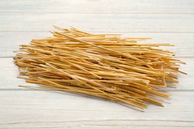 Heap of dried hay on white wooden background, closeup