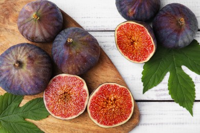 Fresh ripe purple figs on white wooden table, flat lay