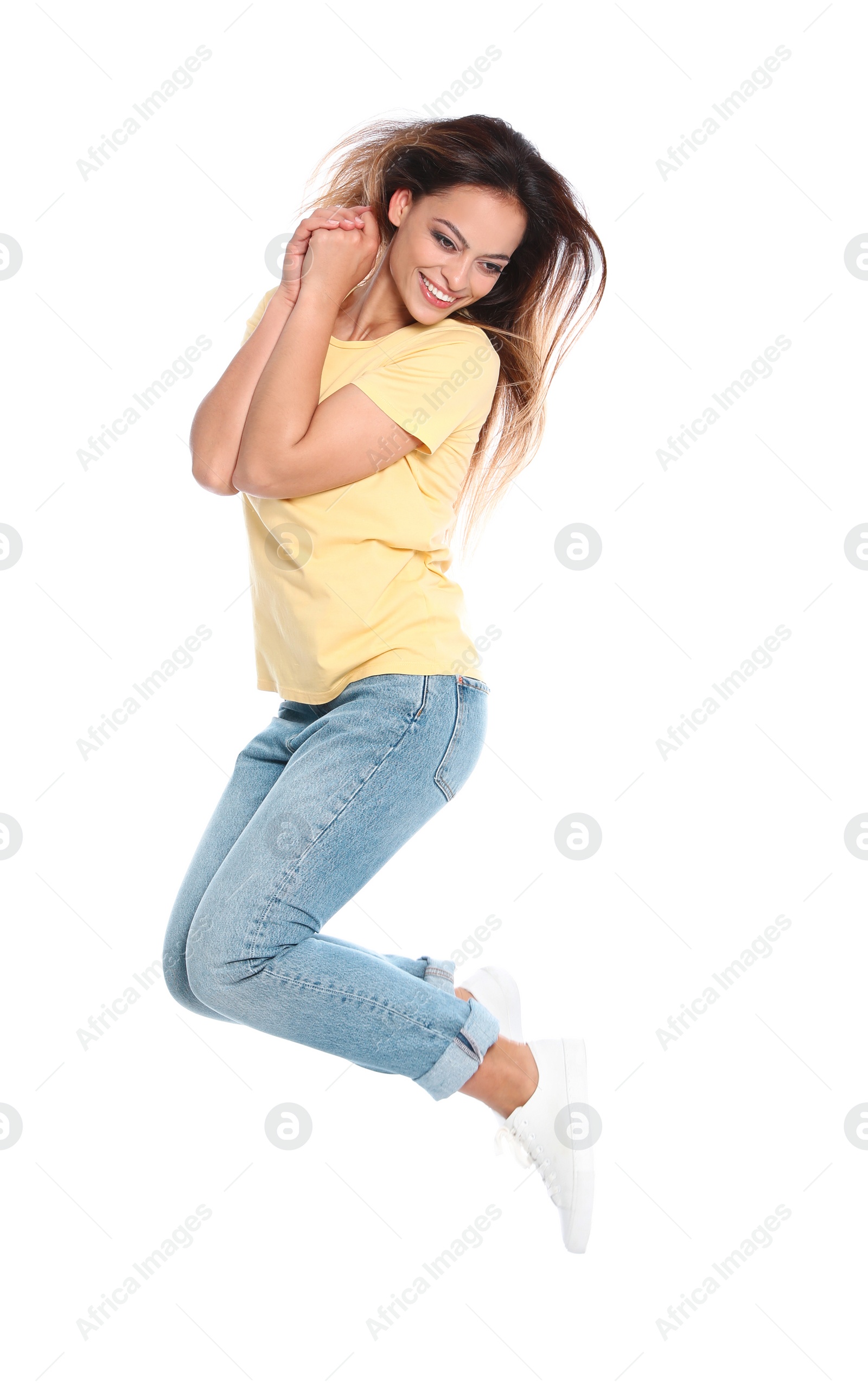 Photo of Happy young woman in casual outfit jumping on white background