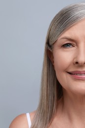 Portrait of beautiful senior woman on grey background, closeup