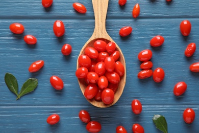 Photo of Fresh ripe goji berries on blue wooden table, flat lay