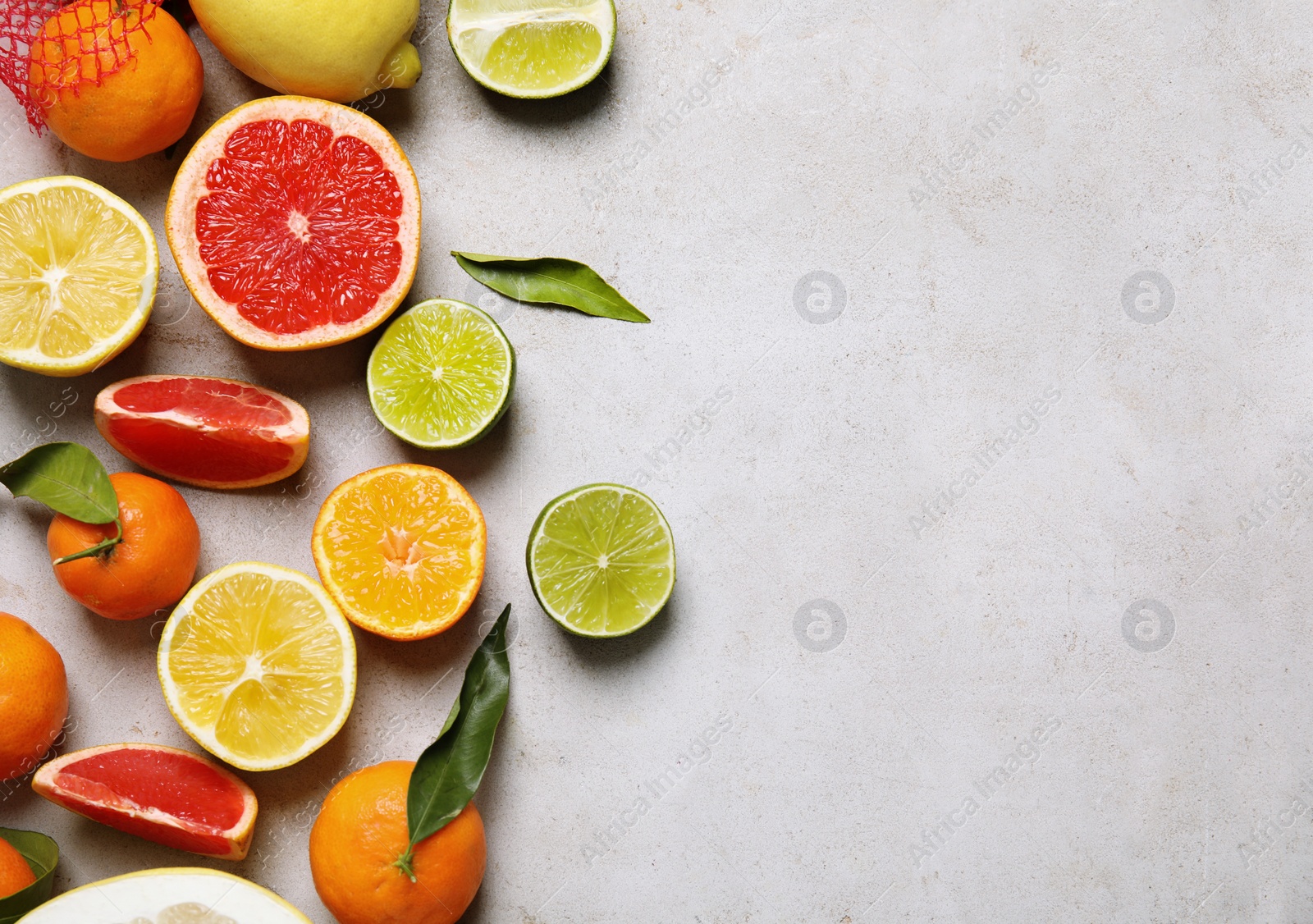 Photo of Different citrus fruits on grey background, top view. Space for text