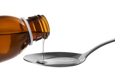 Photo of Pouring syrup into spoon from bottle isolated on white, closeup. Cough and cold medicine