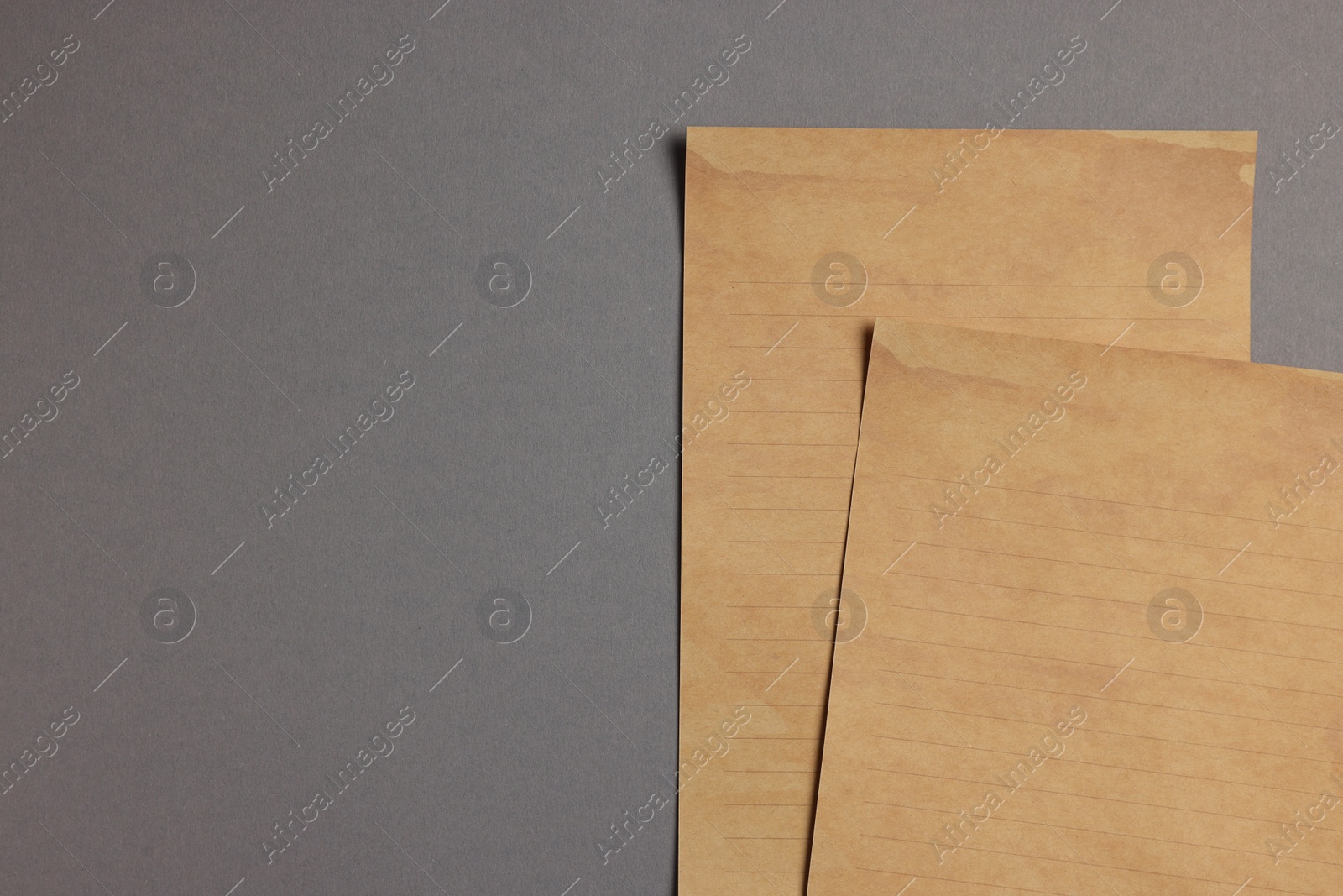 Photo of Sheets of old parchment paper on grey background, flat lay. Space for text