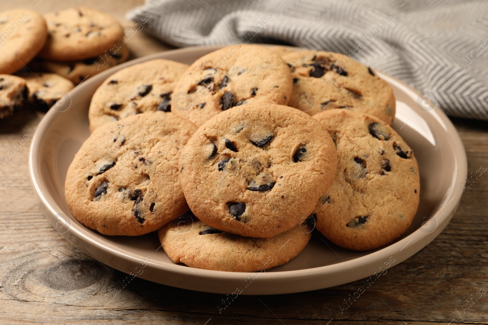Photo of Delicious chocolate chip cookies on wooden table