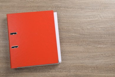 Photo of Red office folder on wooden table, top view. Space for text