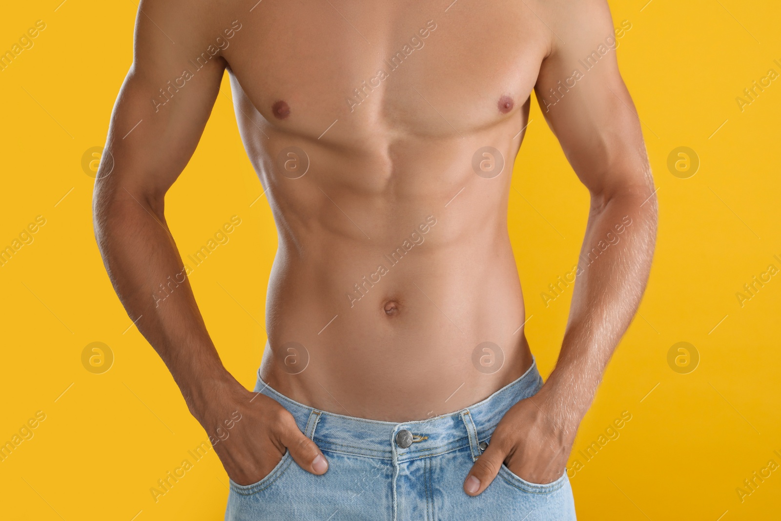 Photo of Shirtless man with slim body on yellow background, closeup