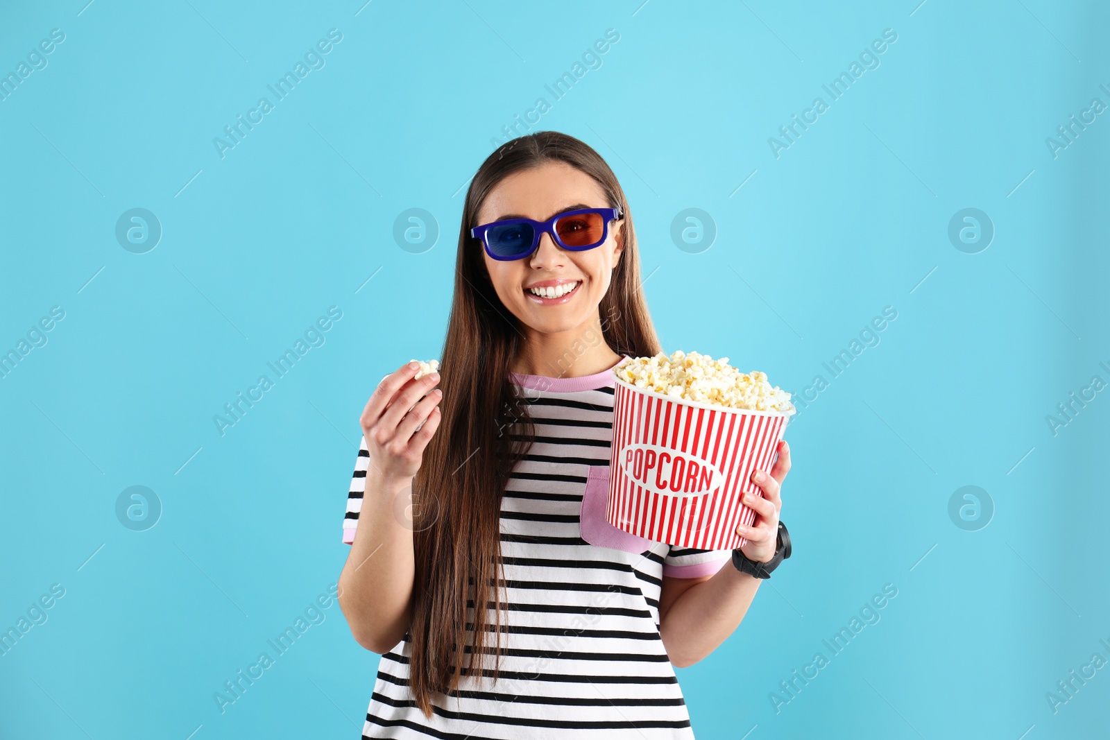 Photo of Young woman with 3D glasses and tasty popcorn on color background