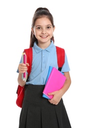 Photo of Cute little girl in school uniform with backpack and stationery on white background