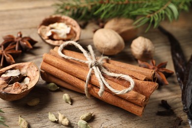 Different spices and nuts on wooden table, closeup