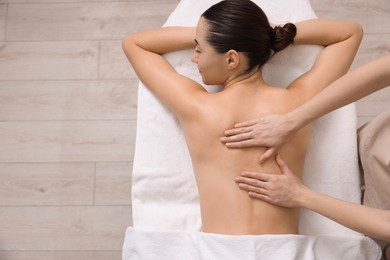 Woman receiving back massage on couch in spa salon, top view. Space for text