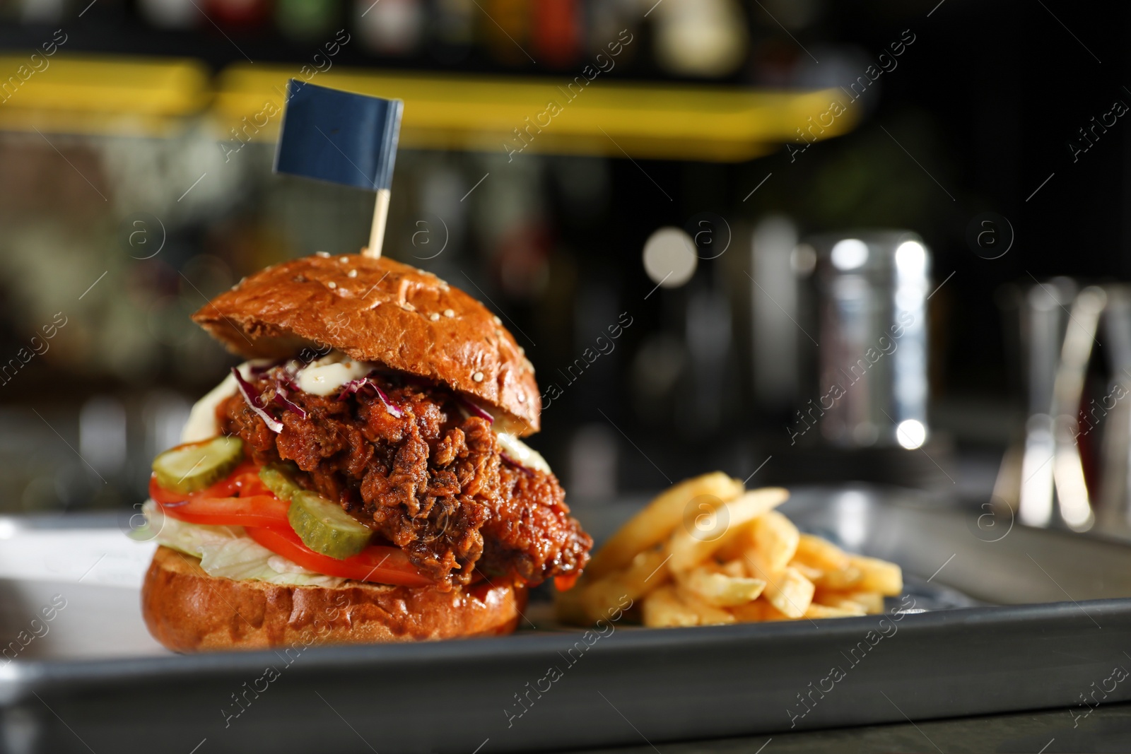 Photo of Tray with delicious burger and french fries on blurred background