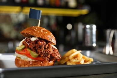 Tray with delicious burger and french fries on blurred background