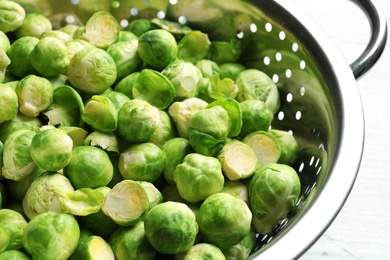 Photo of Tasty fresh Brussels sprouts in colander, closeup