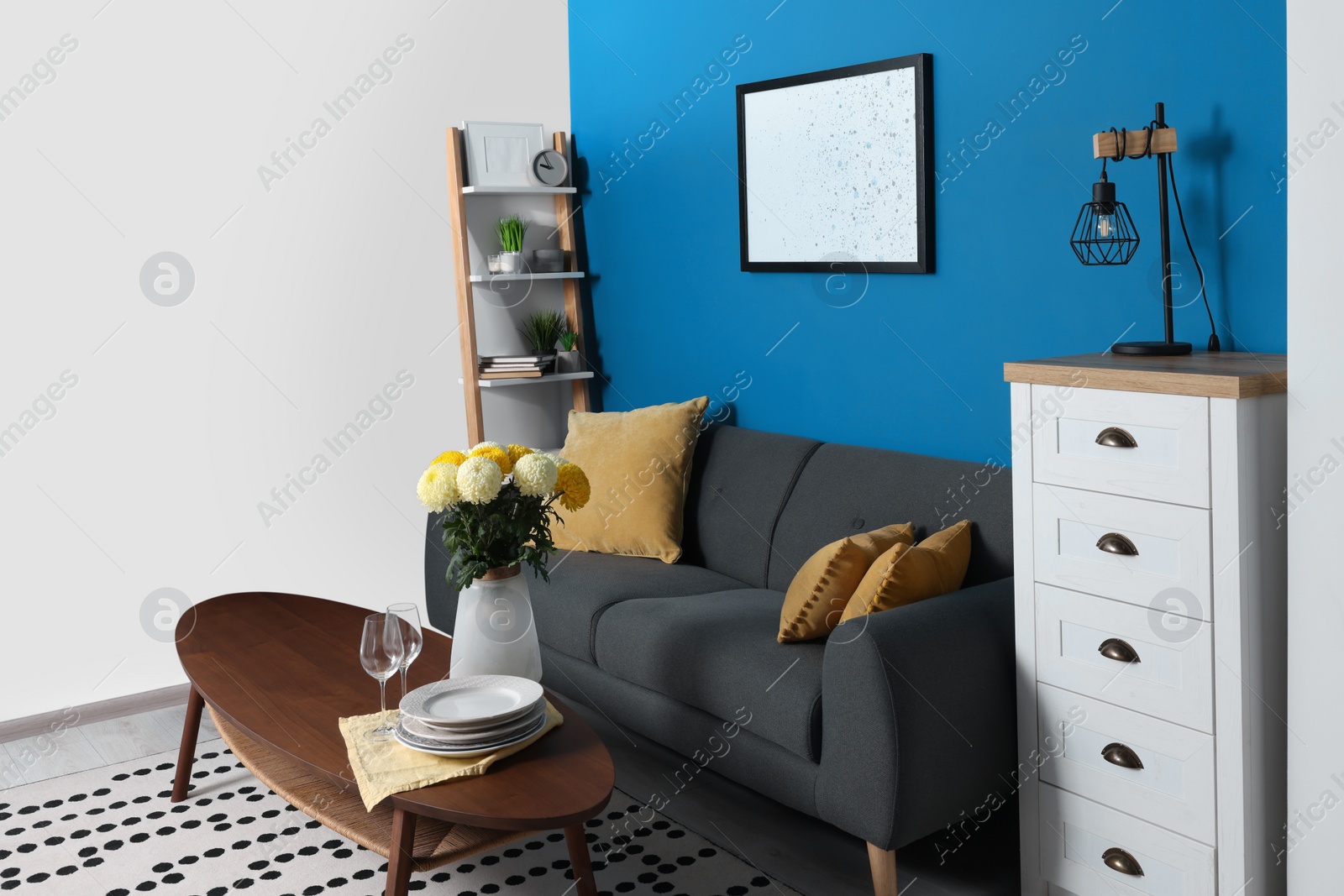 Photo of Stylish living room interior with comfortable grey sofa and coffee table