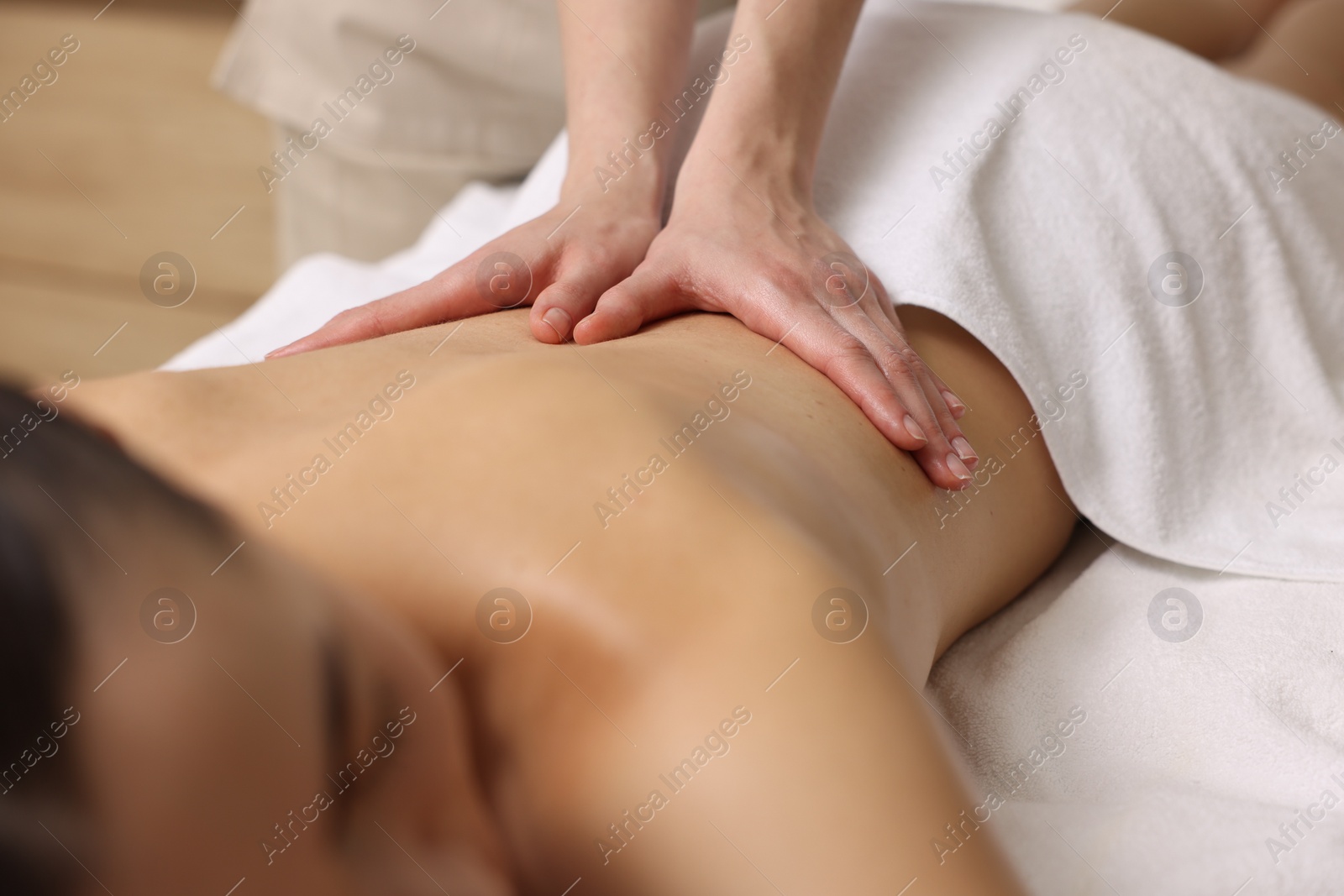 Photo of Woman receiving back massage on couch in spa salon, closeup