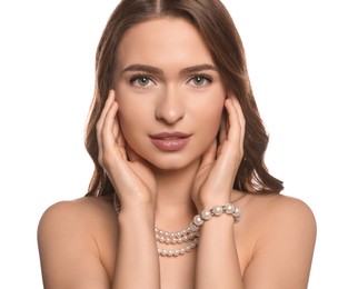Young woman with elegant pearl jewelry on white background