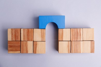 Photo of Bridge made of wooden blocks on light grey background, top view