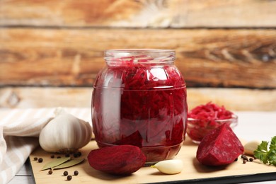 Jar with delicious pickled beetroot and spices on table