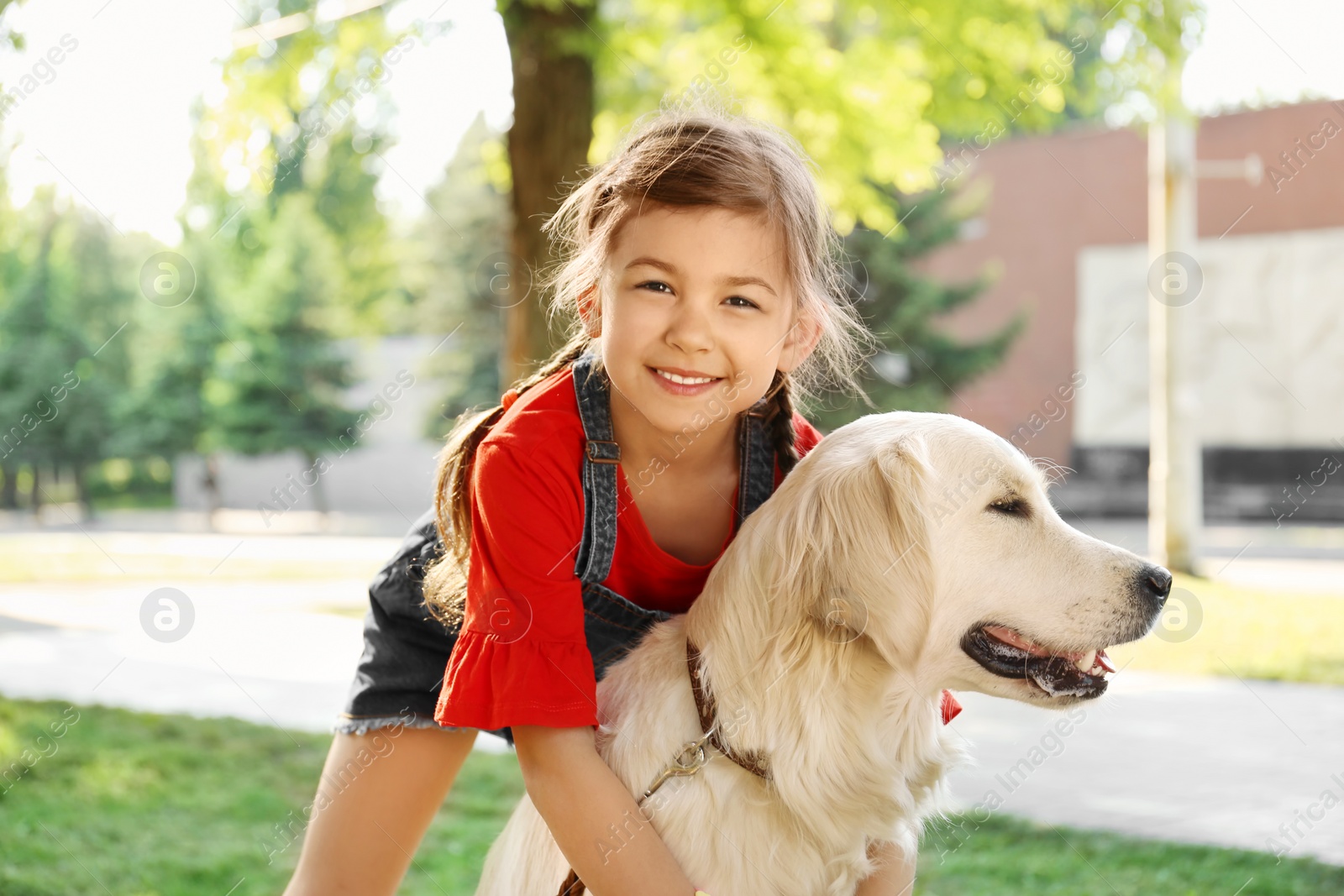 Photo of Cute little child with his pet in green park