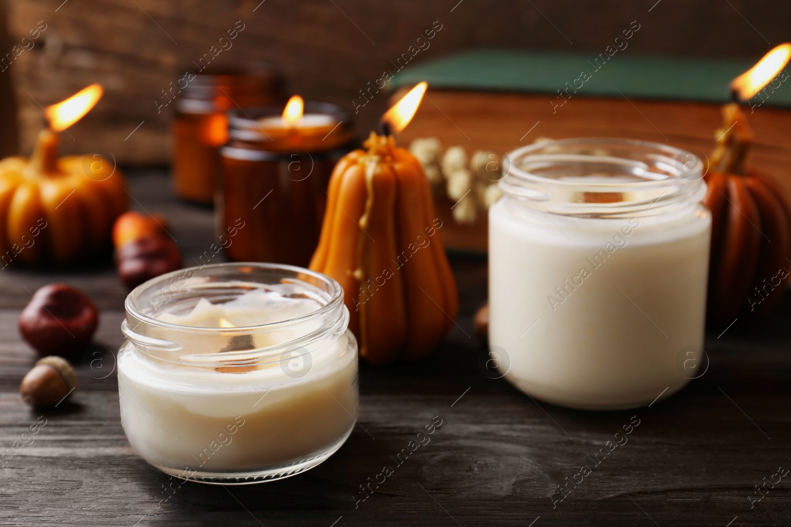 Photo of Many different burning candles on wooden table