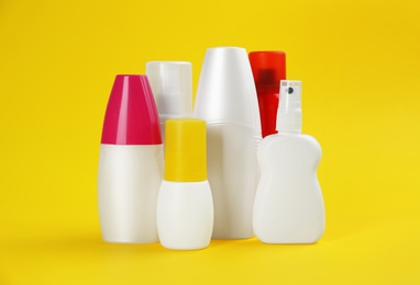Set of different insect repellents on yellow background