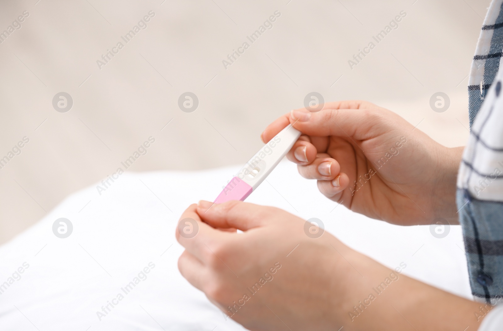 Photo of Young woman with pregnancy test at home, closeup. Space for text