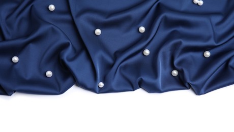 Texture of delicate dark blue silk with pearls on white background, top view