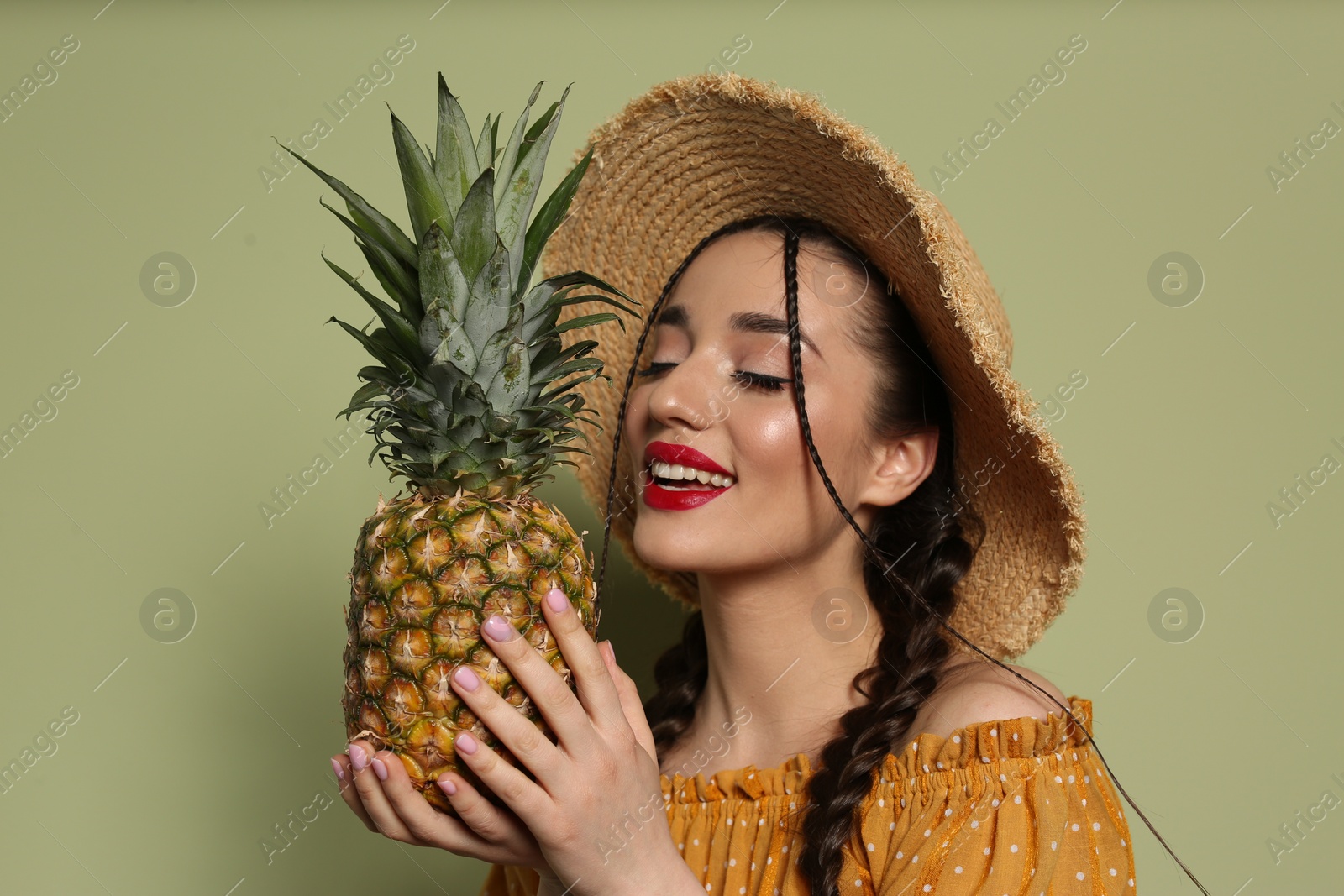 Photo of Young woman with fresh pineapple on olive background. Exotic fruit