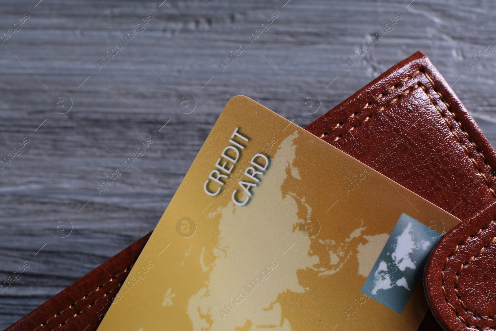 Photo of Credit card and leather wallet on grey table, closeup