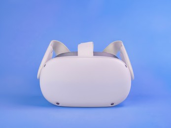 Photo of Modern virtual reality headset on light blue background