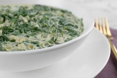 Photo of Tasty spinach dip in white ceramic bowl