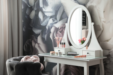 Stylish room interior with elegant dressing table and floral wallpaper