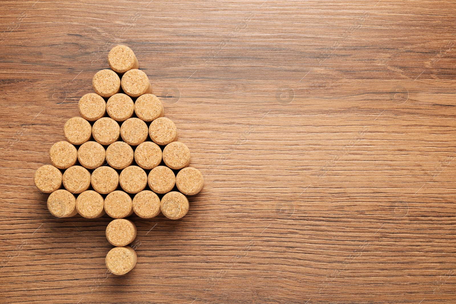 Photo of Christmas tree made of wine corks on wooden table, top view. Space for text