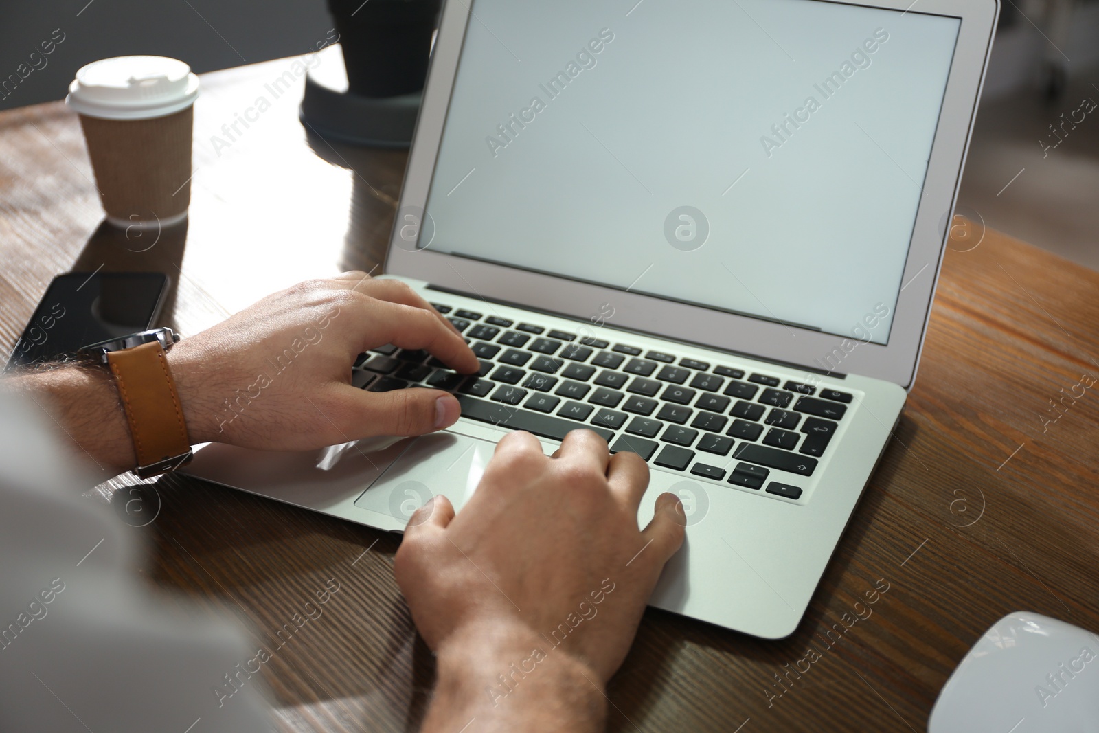 Photo of Freelancer working on laptop at table indoors, closeup