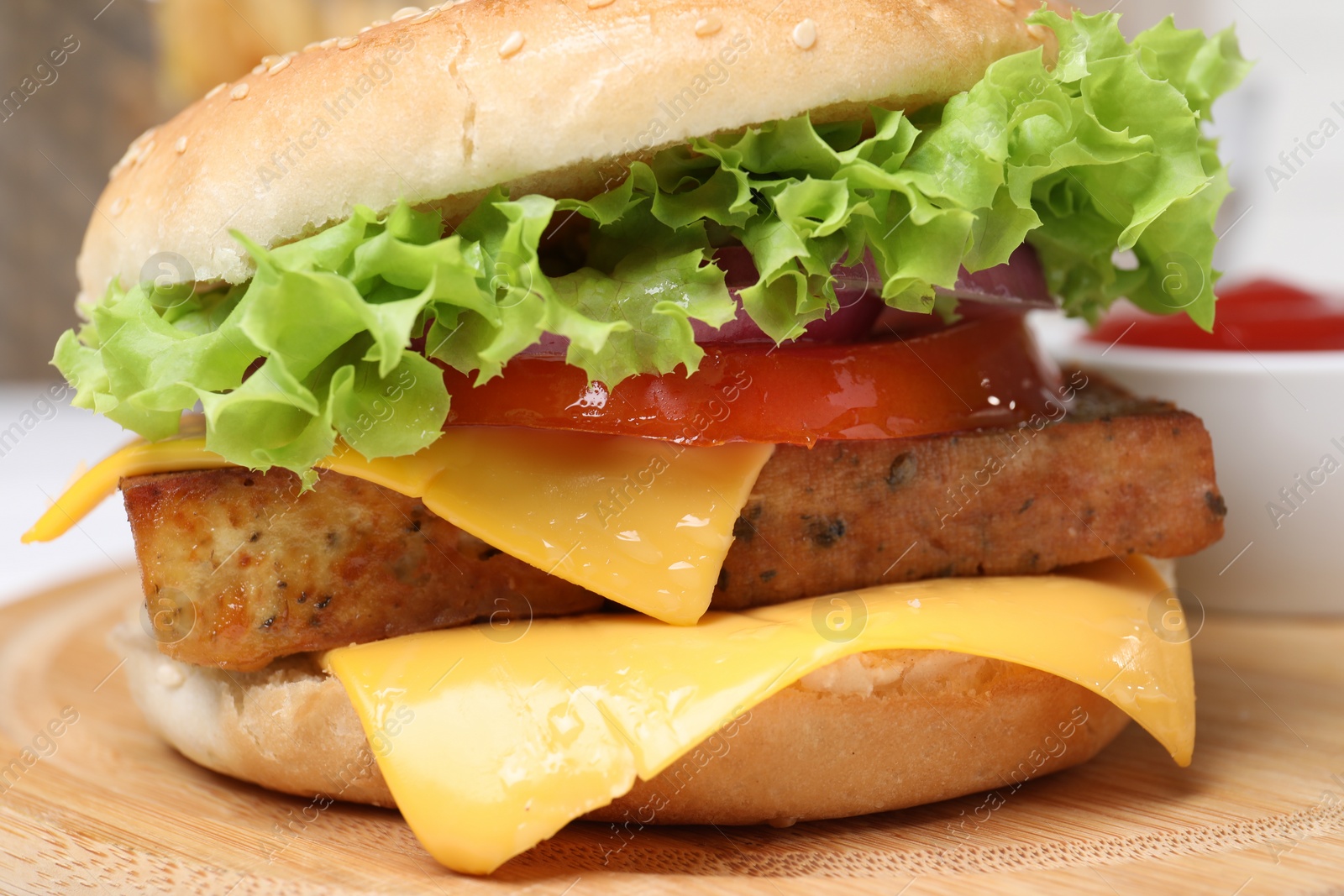 Photo of Delicious burger with tofu and fresh vegetables on wooden table, closeup