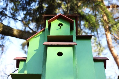 Photo of Green bird house in park, low angle view