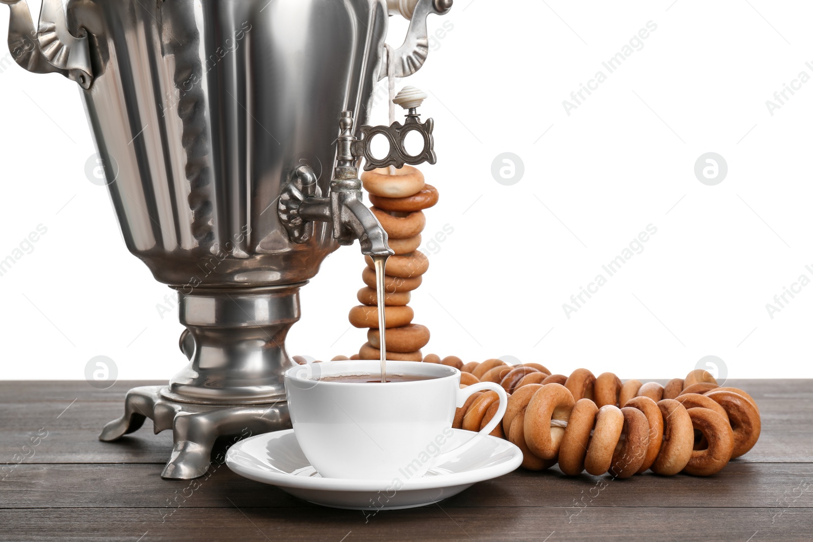 Photo of Samovar with hot tea, jam and delicious ring shaped Sushki (dry bagels) on table against white background