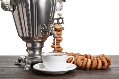 Photo of Samovar with hot tea, jam and delicious ring shaped Sushki (dry bagels) on table against white background