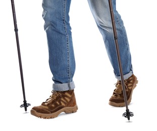 Photo of Man wearing stylish hiking boots with trekking poles on white background, closeup