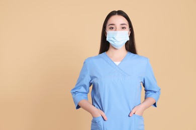 Photo of Nurse wearing protective mask on light brown background, space for text