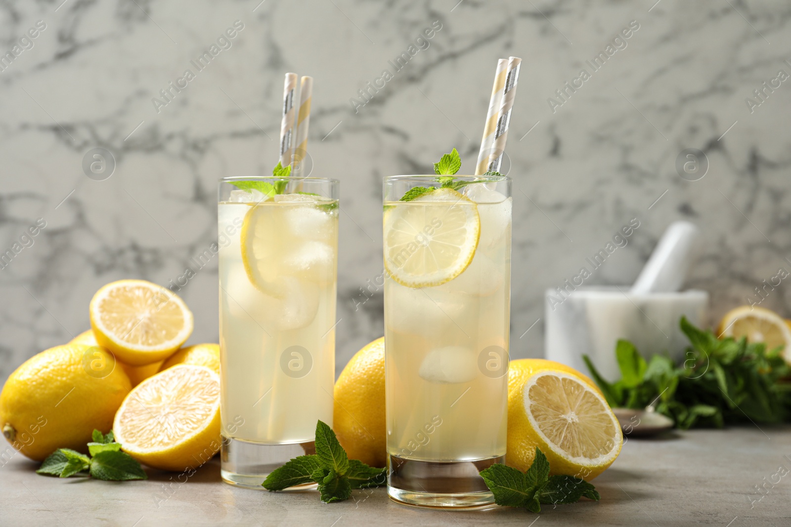 Photo of Natural lemonade with mint and fresh fruits on light grey table. Summer refreshing drink