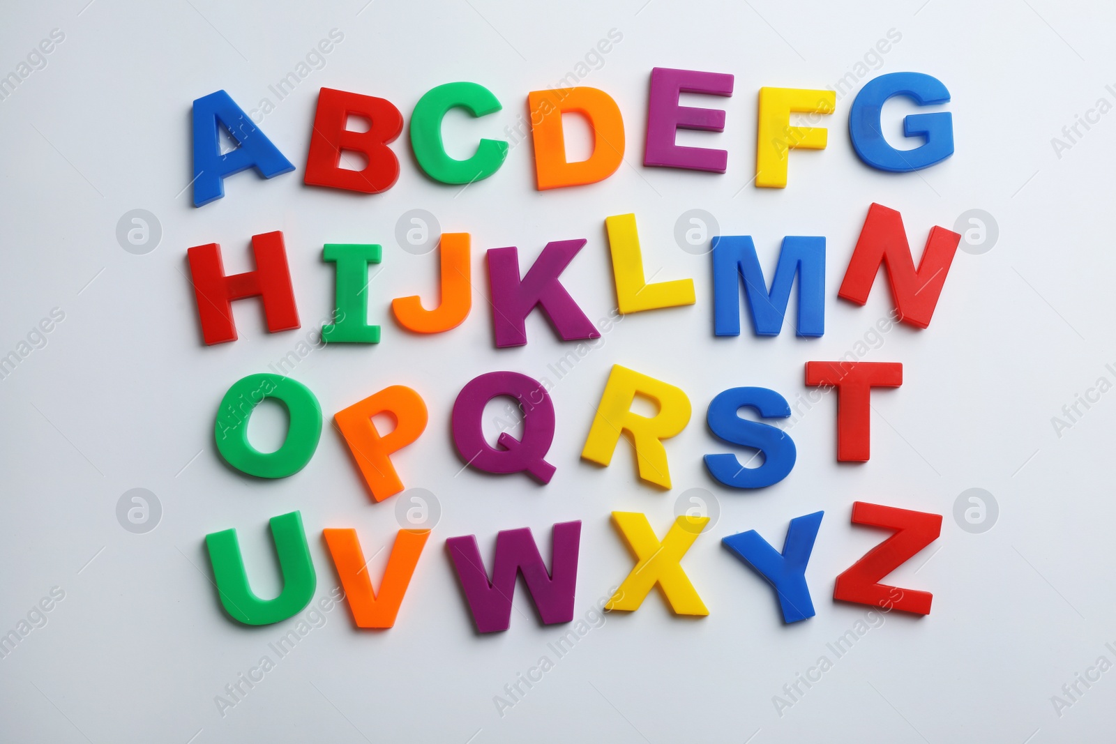 Photo of Plastic magnetic letters isolated on white, top view. Alphabetical order