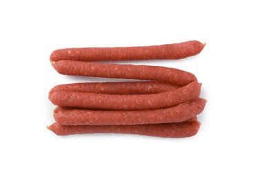 Photo of Thin dry smoked sausages isolated on white, top view