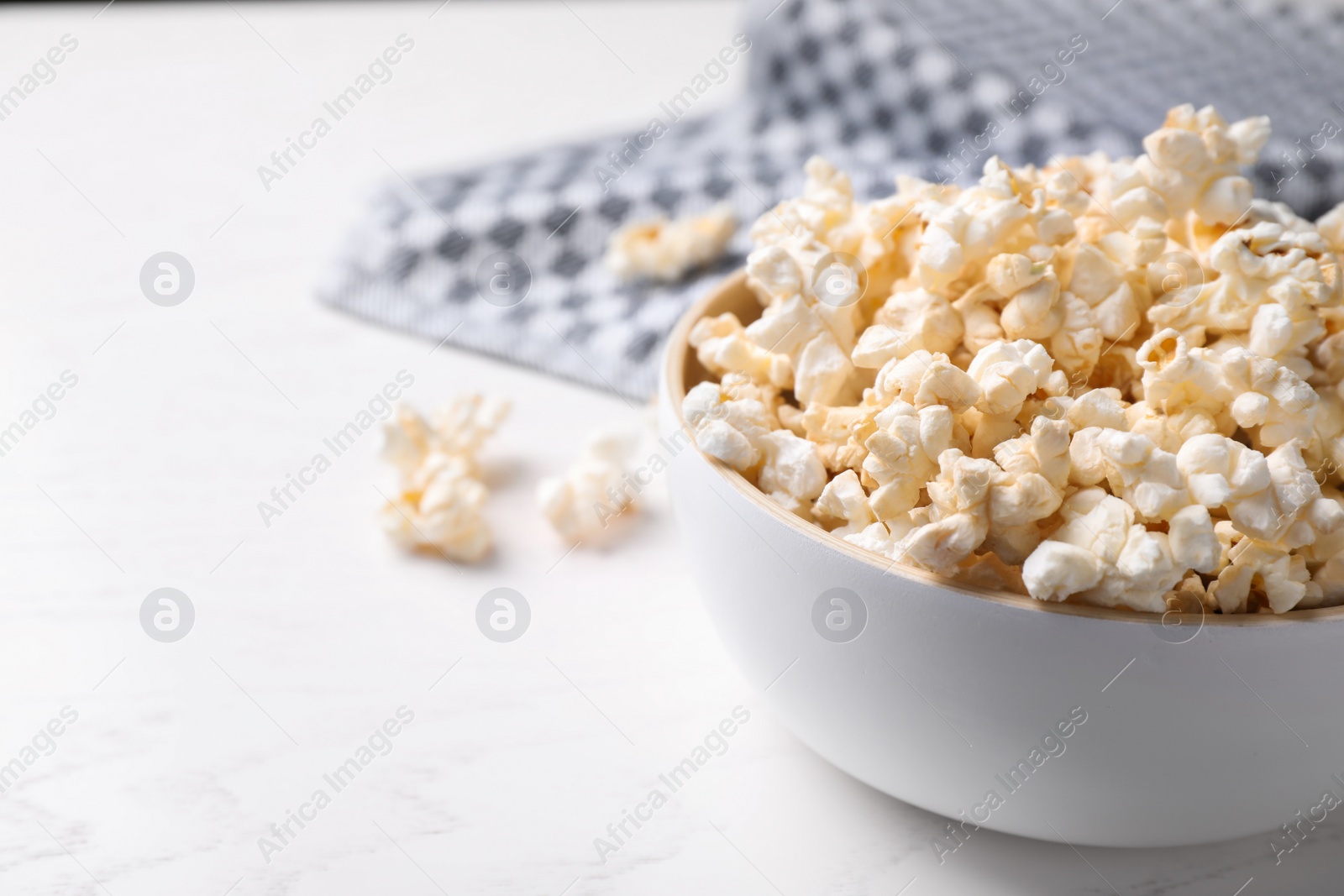 Photo of Delicious popcorn corn on light table, closeup