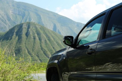 Photo of Black car near beautiful mountains and plants outdoors